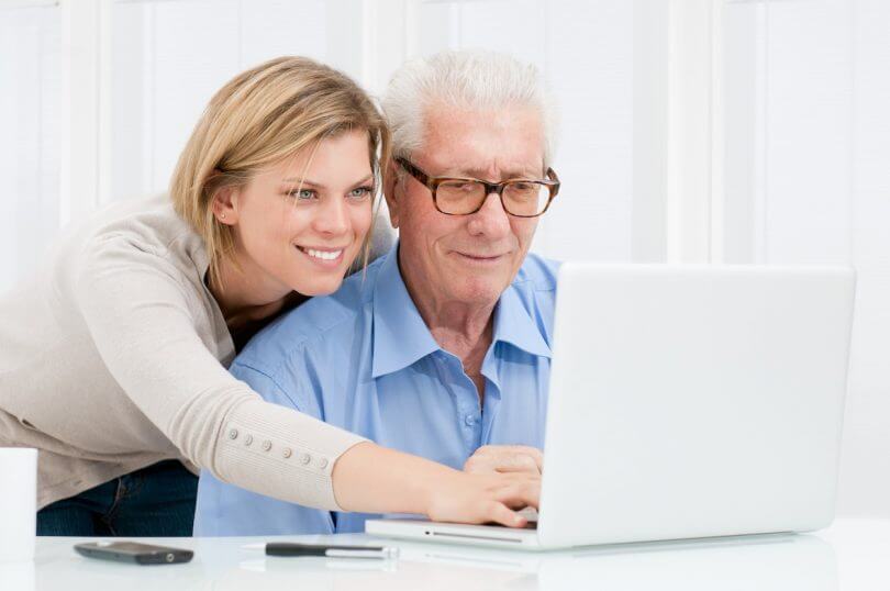 mujer y anciano mirando ordenador