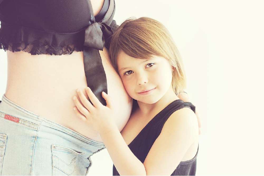 niña sobre barriga de embarazada