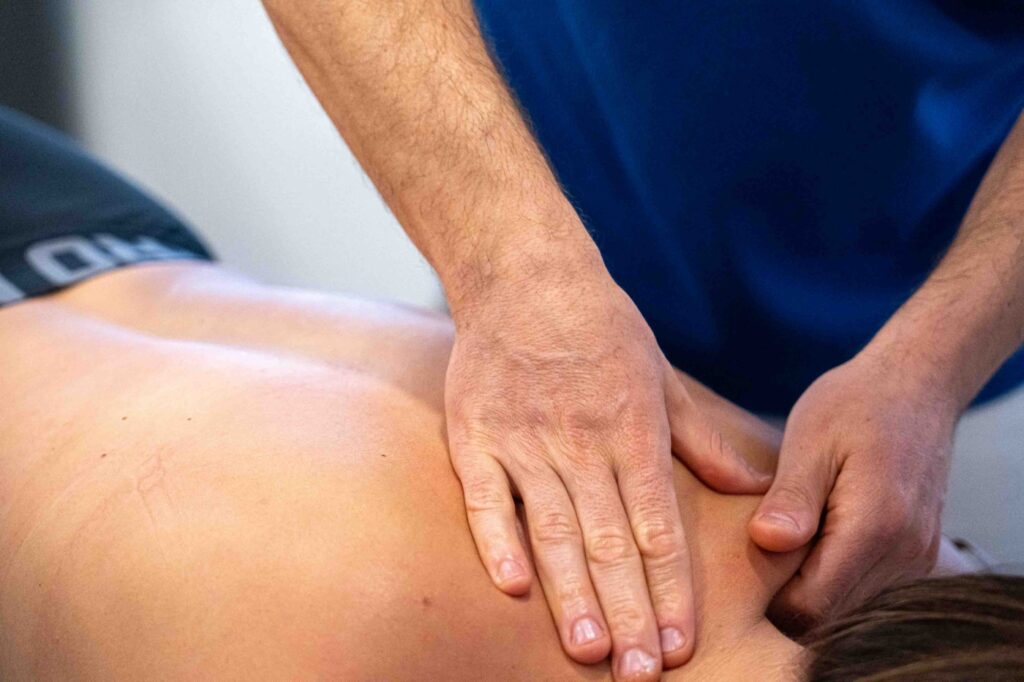 manos del fisio dando masaje en el cuello de la paciente