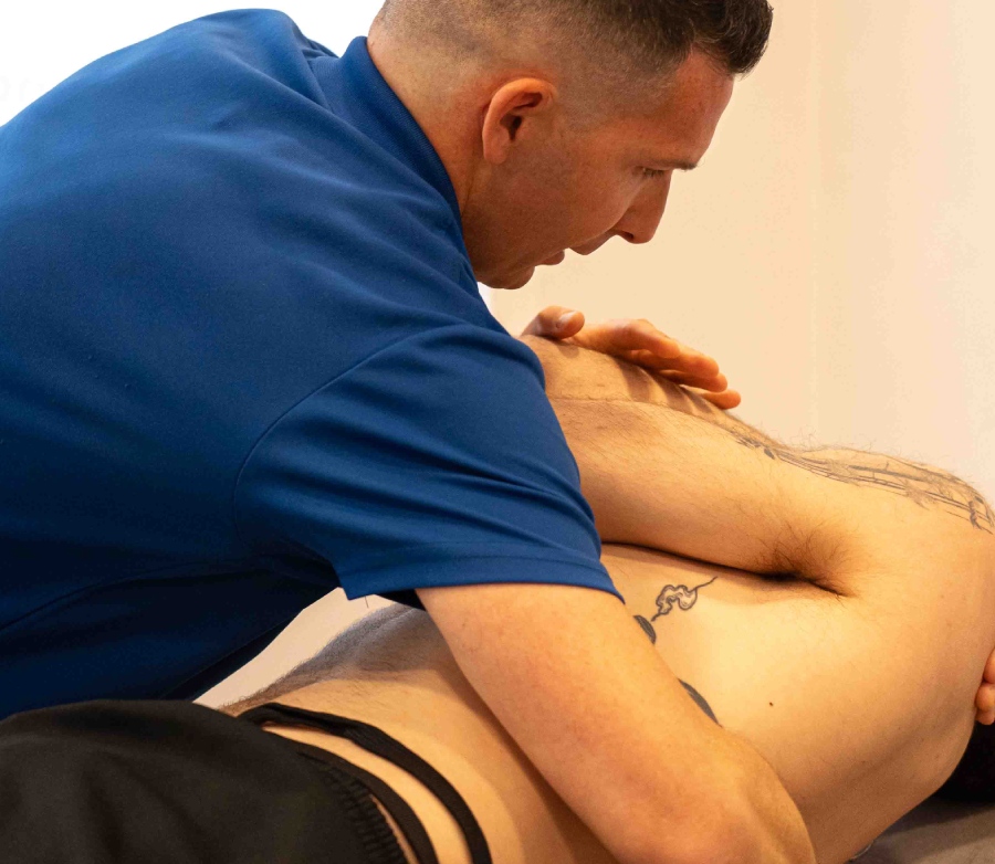 fisio sujetando la espalda de un paciente