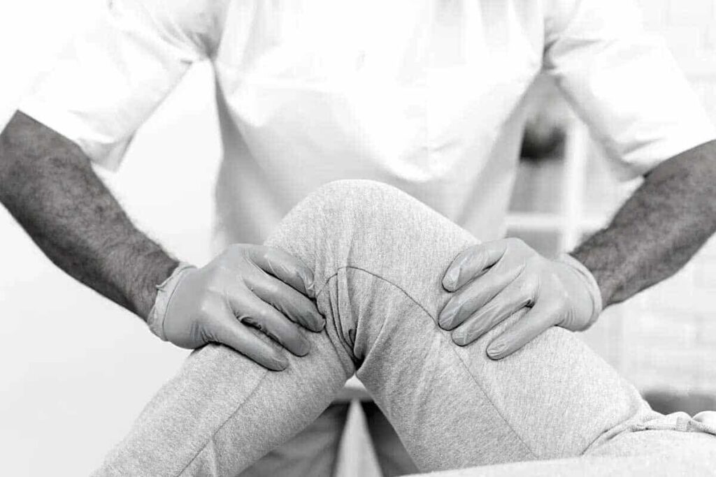 Fisioterapeuta explorando la rodilla de un paciente tras un esguince de rodilla en Leganés.