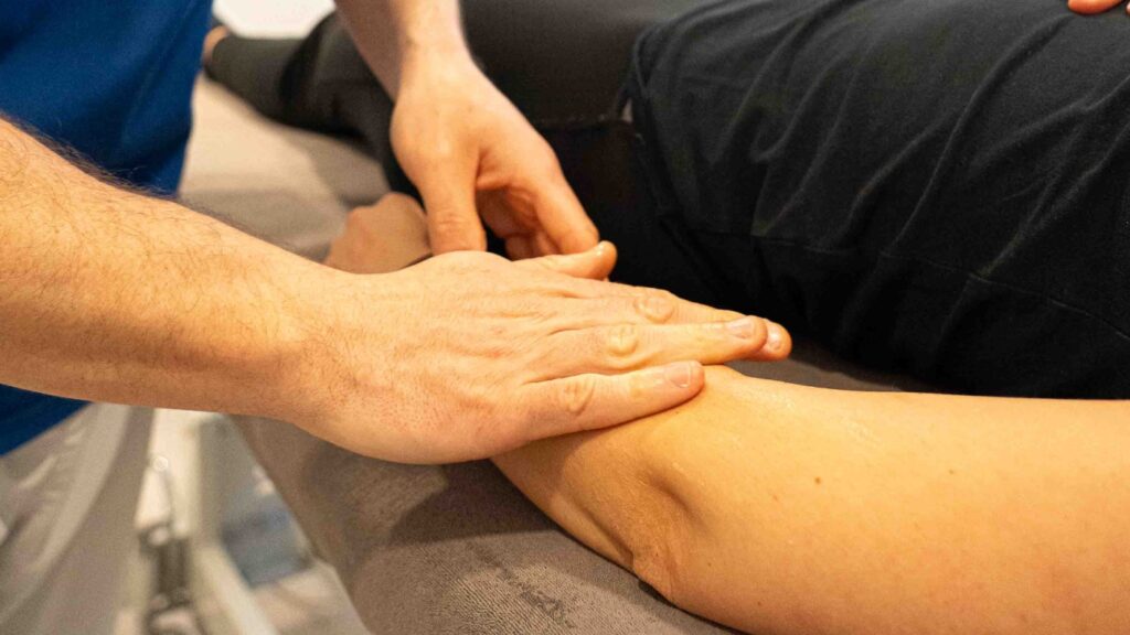 manos del fisio masajeando brazo de la paciente