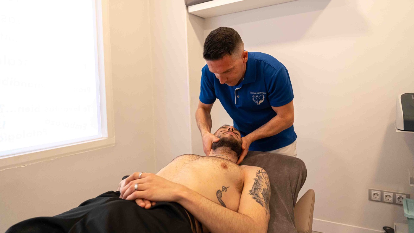 osteopata sujatendo el cuello de un paciente